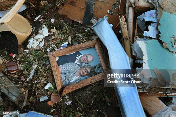 Picture of a couple sits among the debris of a home that was destroyed by yesterday's tornado March 3, 2012 in Henryville, Indiana. Dozens of people...