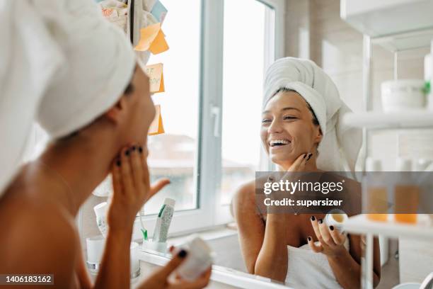 i love feeling my face after my skin care routine - gezichtscrème stockfoto's en -beelden