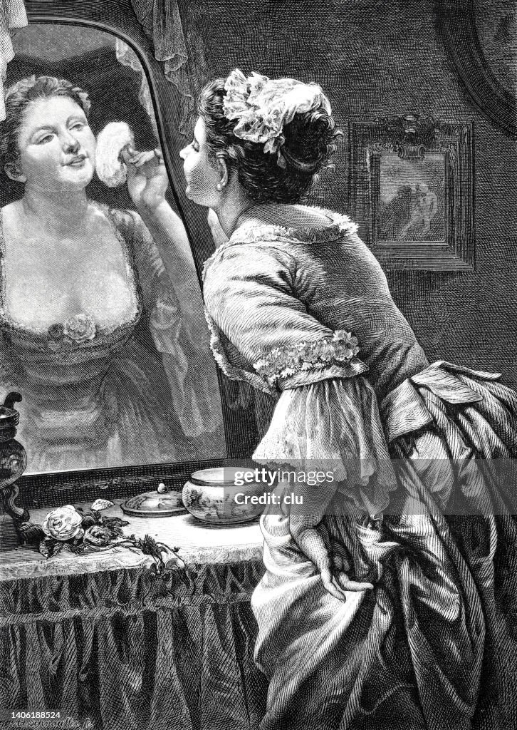 Eine Frau gibt ihrem Make-up im Spiegel zu Hause den letzten Schliff