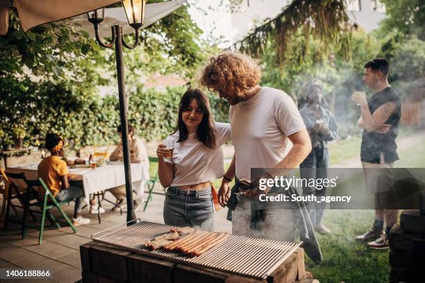 couple on barbecue party - backyard barbeque stock pictures, royalty-free photos & images