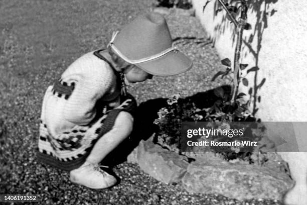 girl of two watching flowers - 1946 stock-fotos und bilder