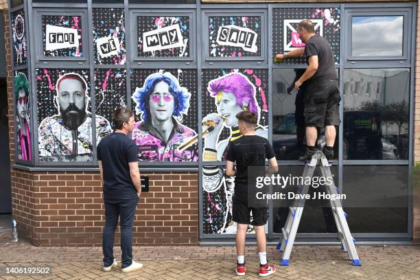 Noel Gallagher looks-on as artists The Postman install a larger than life mural for Noel Gallagher at his North London Studio, London on June 28,...