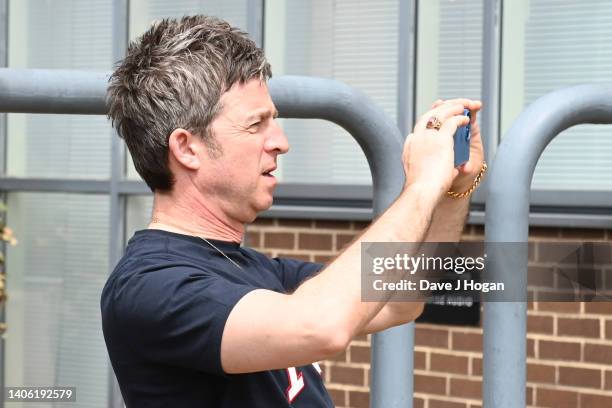 Noel Gallagher takes a photograph as artists The Postman install a larger than life mural for Noel Gallagher at his North London Studio, London on...