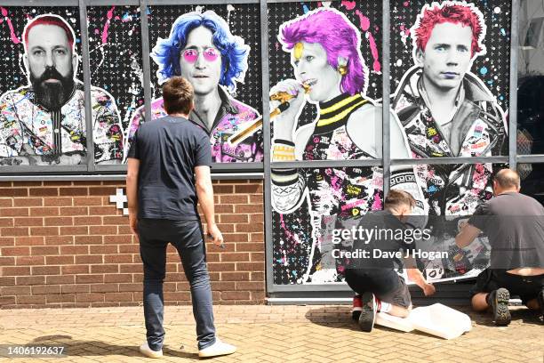 Noel Gallagher looks-on as artists The Postman install a larger than life mural for Noel Gallagher at his North London Studio, London on June 28,...