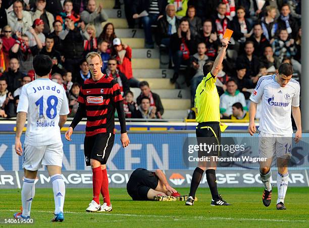 Referee Marco Fritz shows the red card to Kyriakos Papadopoulos of Schalke during the Bundesliga match between SC Freiburg and FC Schalke 04 at...