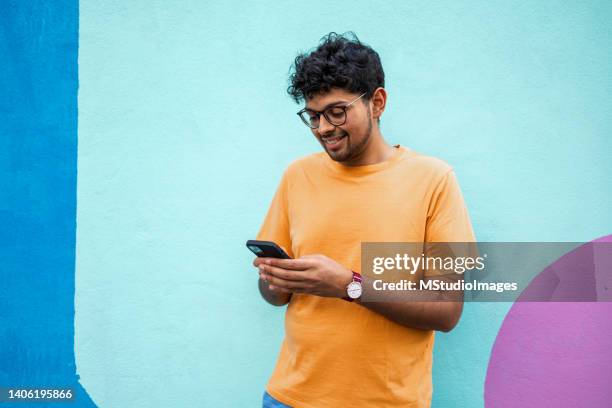 若いハンサムなインド人男性の肖像画。 - asian man texting ストックフォトと画像