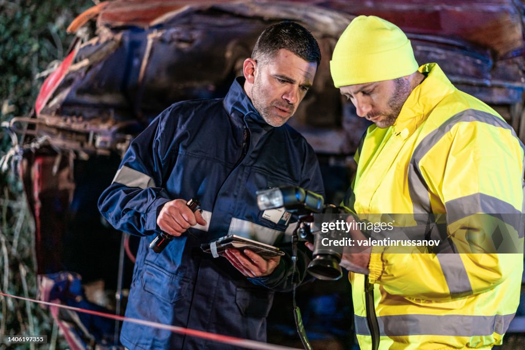Investigating police officer are inspecting the crash site