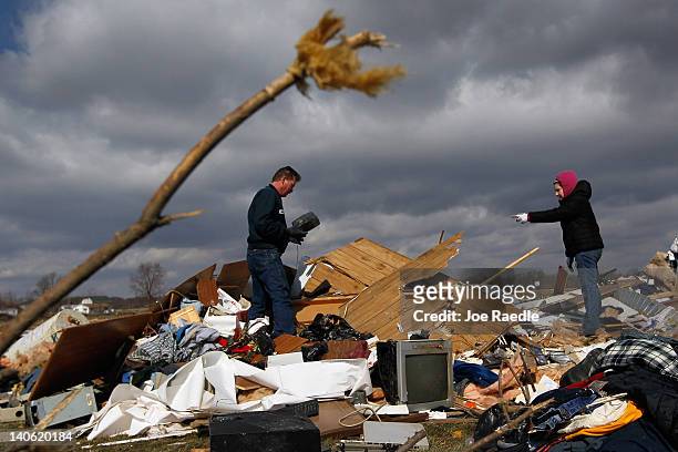 Mark Belanger and April Roberts see what they can salvage from the pile of rubble, which is all that remains of a relative's home that was destroyed...
