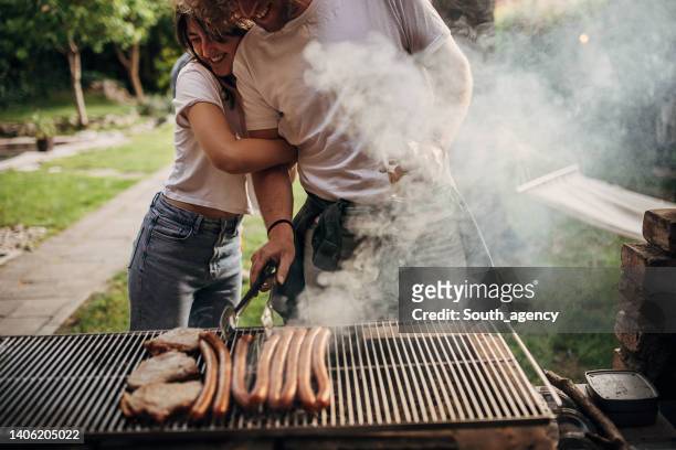 couple on barbecue party - backyard grilling stock pictures, royalty-free photos & images