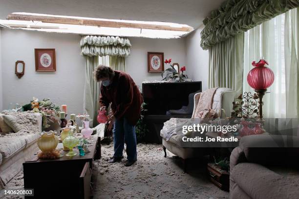 Janine Stauffacher helps salvage what she can from sister Mary Ann Holt's home after it was hit by a tornado that passed through the town on March 3,...