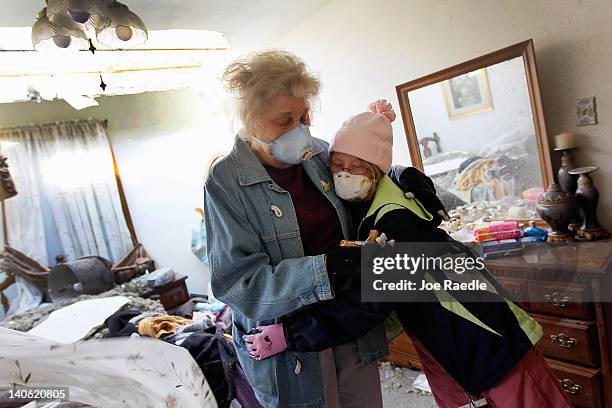 Macy Diekhoff hugs her great aunt, Mary Ann Holt, who survived in the closet of her home, which was hit by a tornado that passed through the town on...