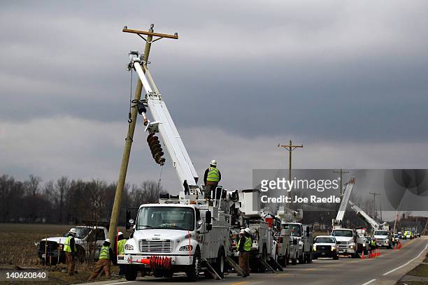 Crews work on replacing power poles, which were knocked over by a tornado that passed through the town on March 3, 2012 in Holton, Indiana. Severe...