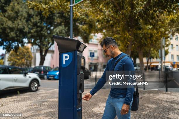 mann bezahlt für das parken mit münzen in einem speziellen geldautomaten in lissabon, portugal - parkuhr stock-fotos und bilder