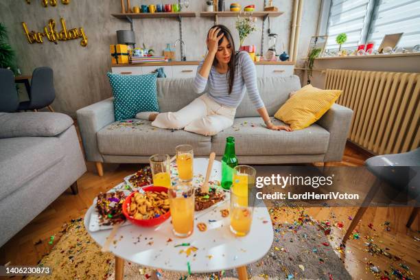 woman with hangover waking up after party - messy house after party stock pictures, royalty-free photos & images