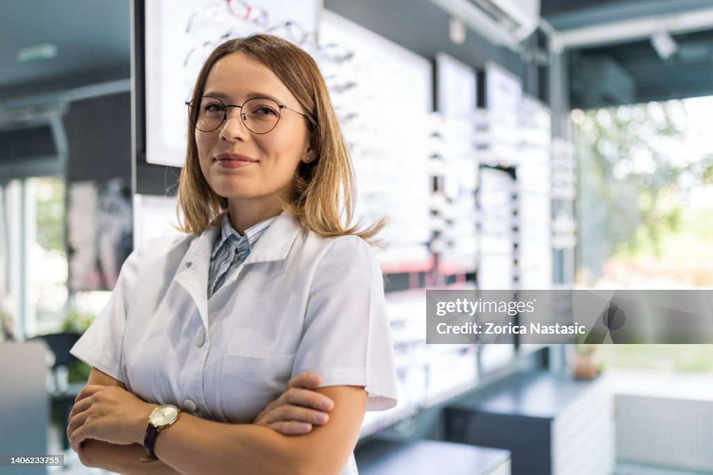 Optician looking at the camera smiling in optical store