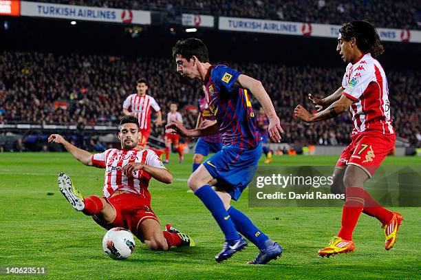 Isaac Cuenca of FC Barcelona duels for the ball with Alberto Botia of Sporting de Gijon and Andre Castro of Sporting de Gijon during the La Liga...