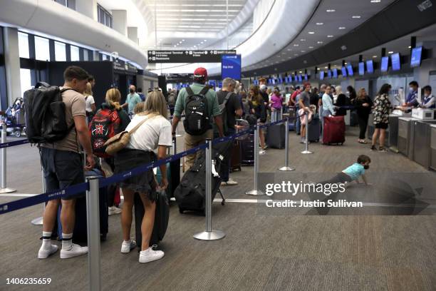 Travelers line up to check in for United Airlines flights at San Francisco International Airport on July 01, 2022 in San Francisco, California....