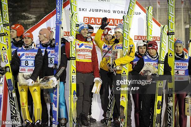 Winning team members, standing at center, from left, Austria's Gregor Schlierenzauer, Martin Koch, Thomas Morgenstern, second-placed team members, at...