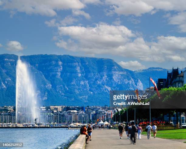 flag lined boardwalk along lake geneva and the geneva water fountain - geneva stock pictures, royalty-free photos & images