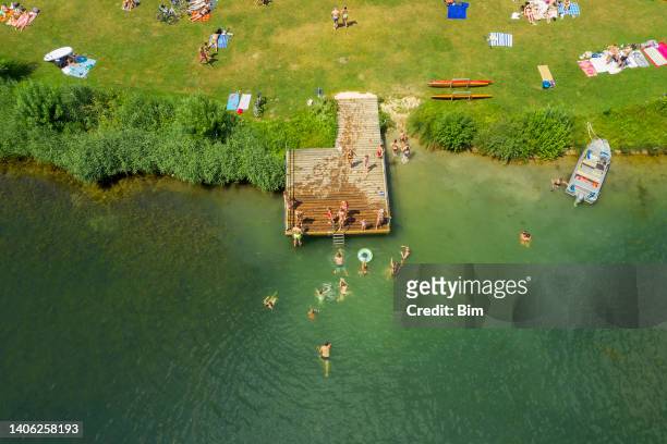 luftaufnahme von menschen sonnenbaden und schwimmen - lake stock-fotos und bilder