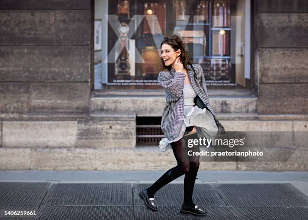 portrait of woman walking on the street and wind blowing her skirt - women in nylons bildbanksfoton och bilder