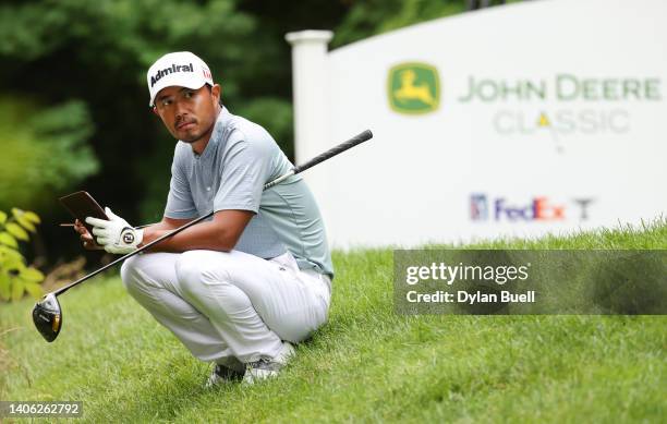 Satoshi Kodaira of Japan checks his scorecard on the 17th tee during the second round of the John Deere Classic at TPC Deere Run on July 01, 2022 in...