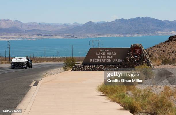 Vehicle towing a boat drives past a sign welcoming visitors to the Lake Mead National Recreation Area on July 01, 2022 in the Lake Mead National...