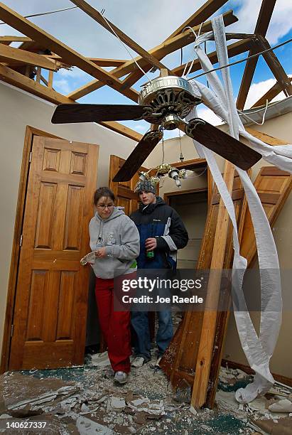 Eric Craven and Kirstie Craven walk through what is left of her parents' home after it was blown off its foundation by a tornado that passed through...