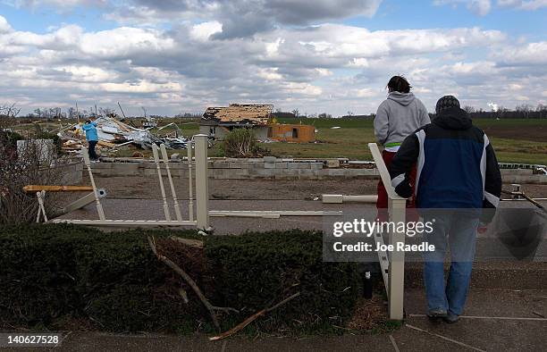 Eric Craven and Kirstie Craven walk onto the front porch of her parents home, now seen in the background, after it was blown off its foundation by a...
