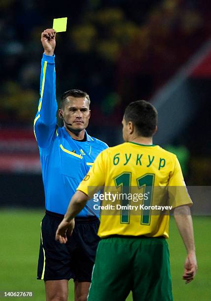 Referee Vladislav Bezborodov shows a yellow card to Gheorghe Bucur of FC Kuban Krasnodar during the Russian Football League Championship match...