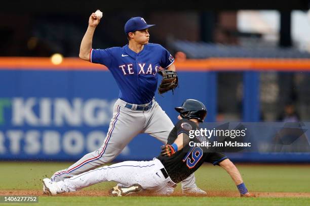 Corey Seager of the Texas Rangers completes a second inning double play after forcing out Mark Canha of the New York Mets at Citi Field on July 01,...