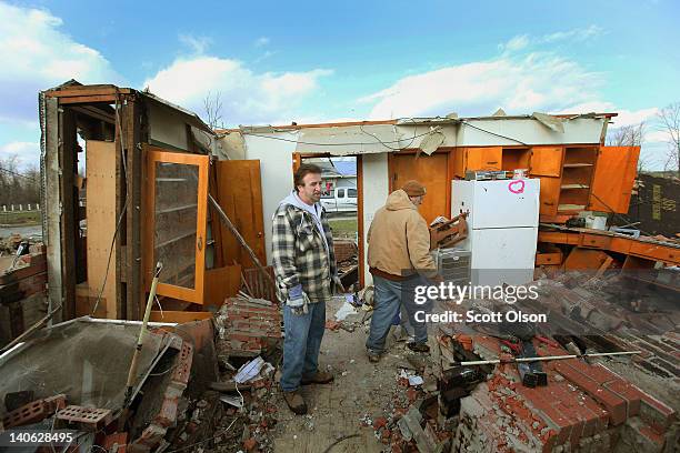 Brothers Bob and Jim Mappins stand in the kitchen of a home that belonged to their mother after it was destroyed by a tornado March 3, 2012 in...