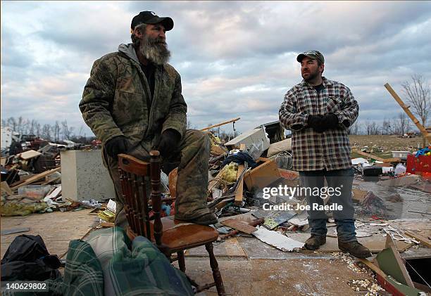 David Cox and his son, Josh Cox, stand on what remains of Josh's home after it was destroyed by a tornado on March 3, 2012 in Chelsea, Indiana....