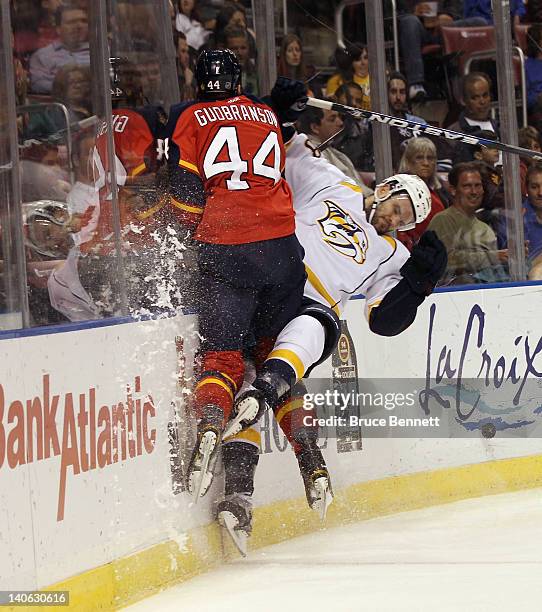 Erik Gudbranson of the Florida Panthers hits Paul Gaustad of the Nashville Predators into the boards at the BankAtlantic Center on March 3, 2012 in...