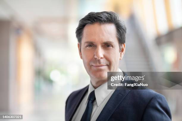 portrait of successful mature businessman standing in office - politician stock pictures, royalty-free photos & images