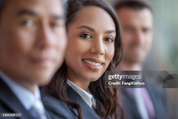 portrait of young multiracial black businesswoman smiling in meeting with colleagues in a row - collaboration government stock pictures, royalty-free photos & images