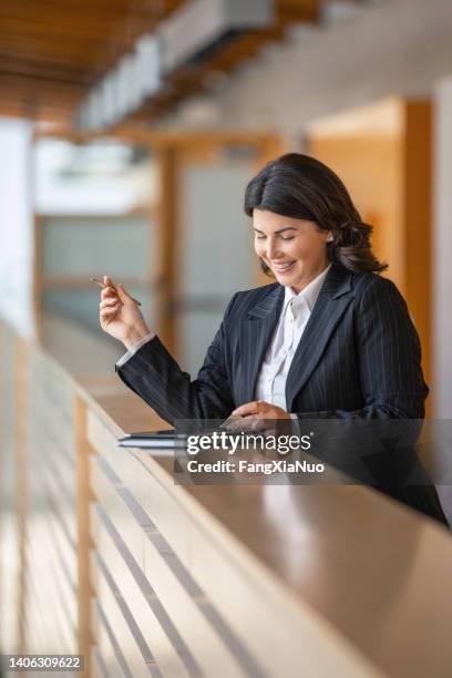 portrait of young caucasian businesswoman surfing the internet with digital tablet in office lobby on railing - student government stock pictures, royalty-free photos & images