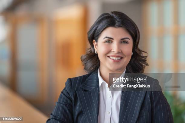 retrato de una joven empresaria caucásica sonriendo a la cámara en el vestíbulo de la oficina en traje de negocios - thick white women fotografías e imágenes de stock