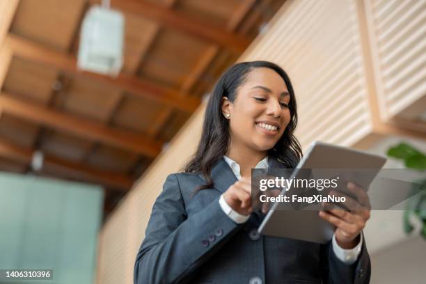 retrato de una empresaria negra afroamericana multirracial que usa internet con vista de ángulo bajo de tableta digital - político fotografías e imágenes de stock