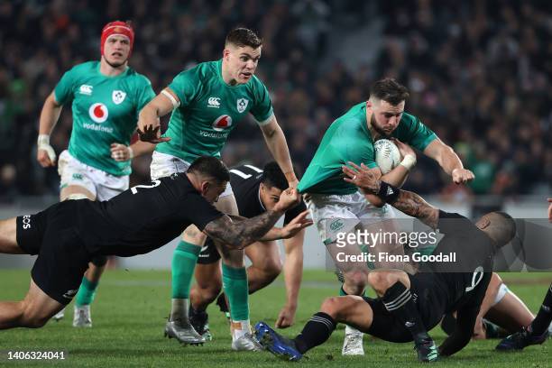 Robbie Henshaw of Ireland is tackled by Codie Taylor of the All Blacks during the International test Match in the series between the New Zealand All...