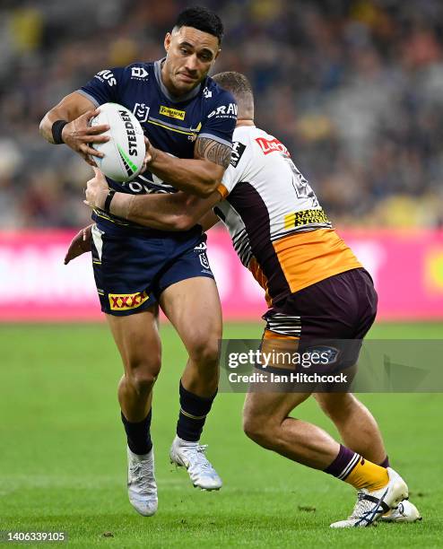 Valentine Holmes of the Cowboys is tackled by Brenko Lee of the Broncos during the round 16 NRL match between the North Queensland Cowboys and the...