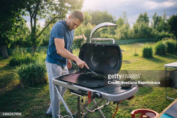 father cleans the grill - cleaning person stock-fotos und bilder