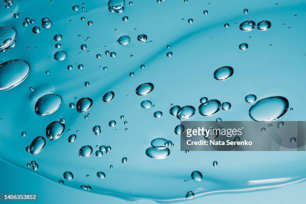 close up macro aloe vera gel serum cosmetic texture blue background with bubbles. - oil macro stock pictures, royalty-free photos & images