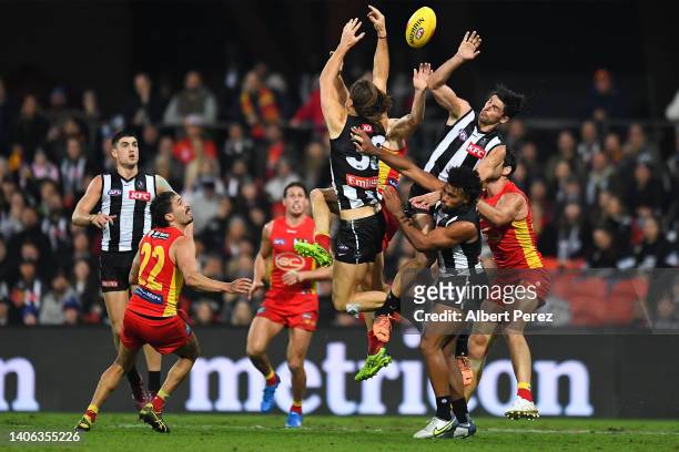 Players compete for the ball during the round 16 AFL match between the Gold Coast Suns and the Collingwood Magpies at Metricon Stadium on July 02,...
