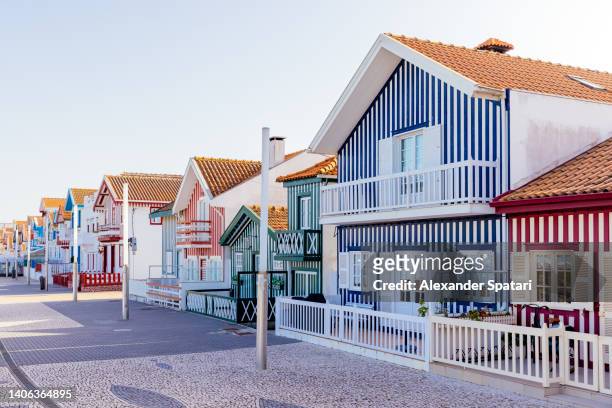 traditional striped multi colored houses in costa nova, aveiro, portugal - distrikt aveiro stock-fotos und bilder
