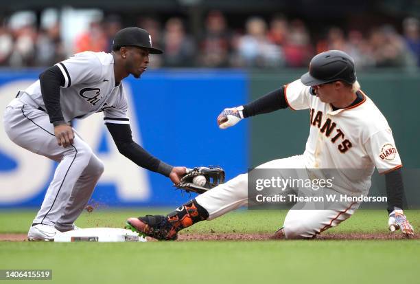 Joc Pederson of the San Francisco Giants slides into second base with a double ahead of the tag from Tim Anderson of the Chicago White Sox in the...