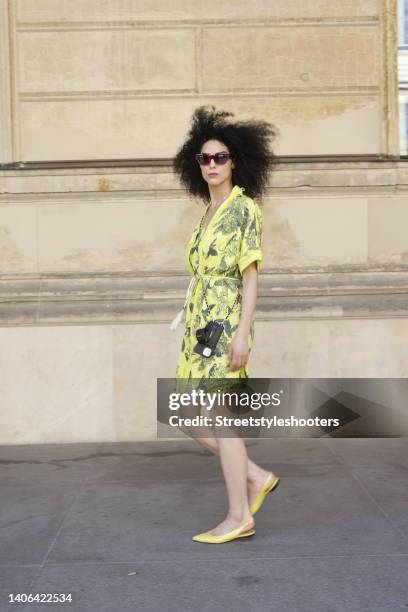 Model and artist Zoe Helali wearing a yellow top, shorts and jacket with floral and animal print by Miss Goodlife, a black and gold phone case with...