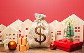 Dollar money bag and houses in a New Year's setting. Increase in investment attractiveness, prosperity. Mortgage loans. Bank deposit, credit. Promotions, offers. New Year or Xmas winter holiday.