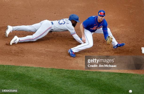 Adolis Garcia of the Texas Rangers dives safely back to first base during the second inning on a pick off attempt by Pete Alonso of the New York Mets...