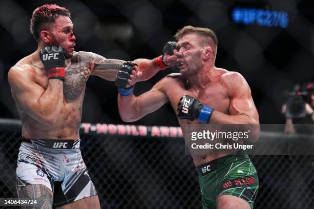 Brad Tavares punches Dricus Du Plessis of South Africa in a middleweight fight during the UFC 276 event at T-Mobile Arena on July 02, 2022 in Las...